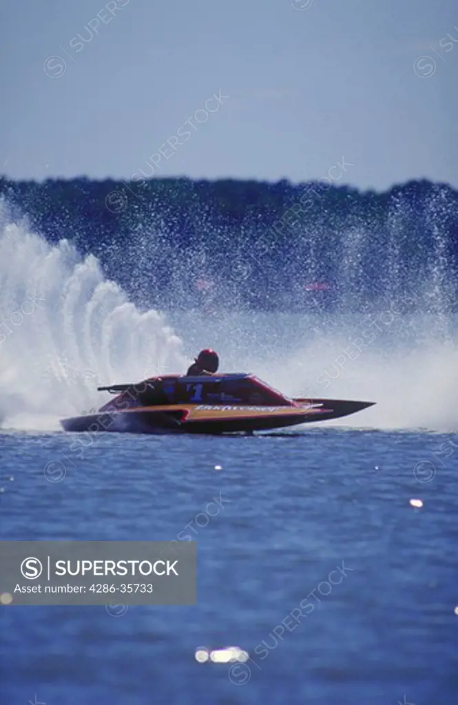Hydroplane boat, racing.  Waterspray flying as this boat goes into the first turn of the racecourse at Kent Narrows in the Chesapeake Bay. Taken during a sanctioned professional race.