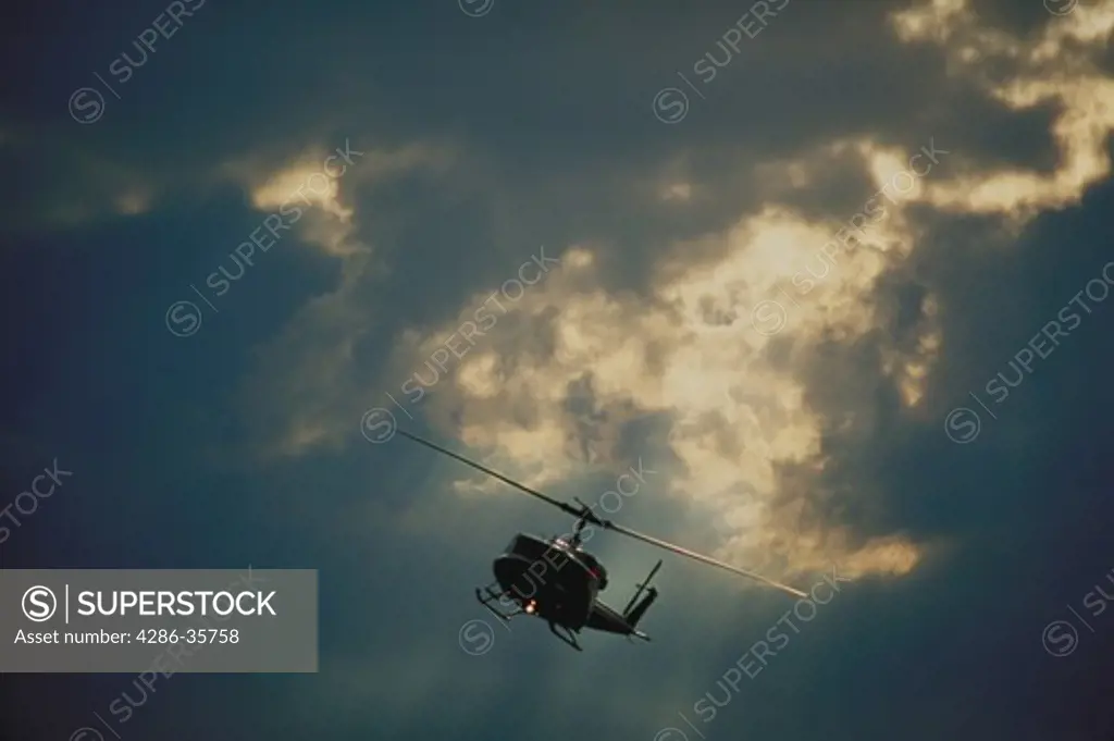 Helicopter in flight, with dramatic sky.  (Aviation.  Skies.)
