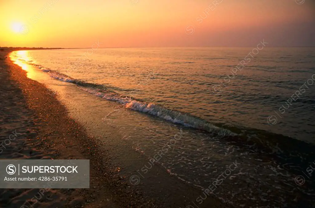 Beach.  Shoreline, in early morning, (or late afternoon) golden light. Peaceful and inviting. (Concept. Seascape. Travel. American landscape.)
