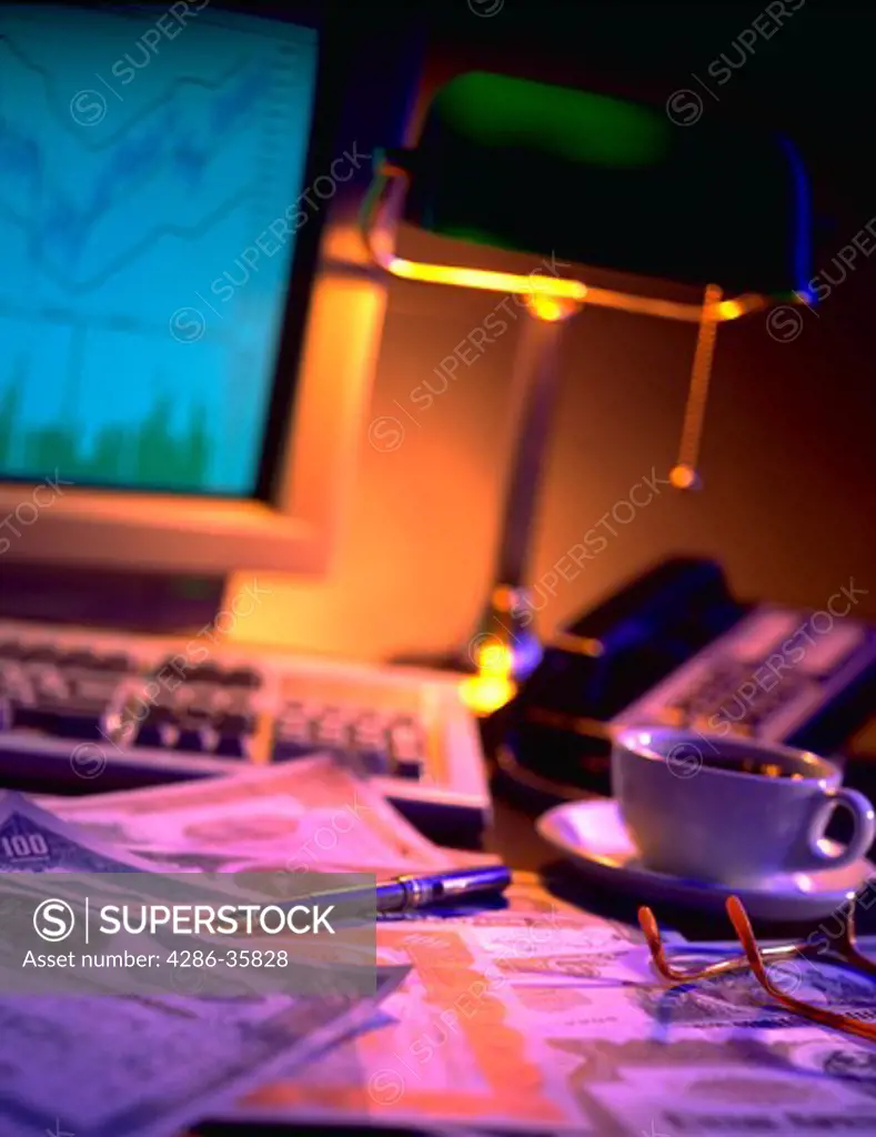 Computer, telephone, stock certificates and pen sitting on desk.