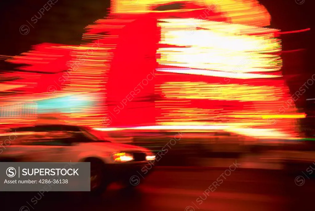 Taxi speeding by the neon lights of a casino on the Las Vegas strip at night, with blurred effect.