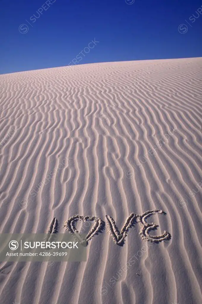 Word LOVE written in the sand.