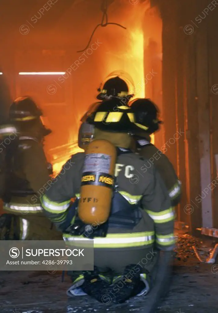 Firefighters going into action into a blazing building. 