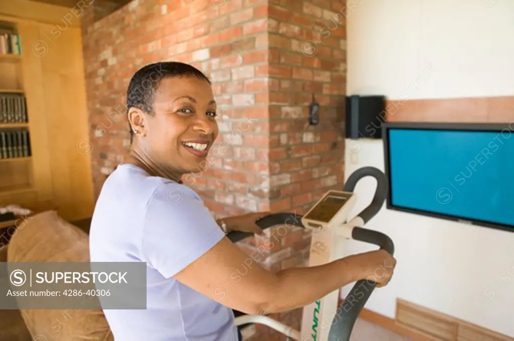 Senior, African American, exercising on stepper machine and plasma TV  MR-0510 PR-0505