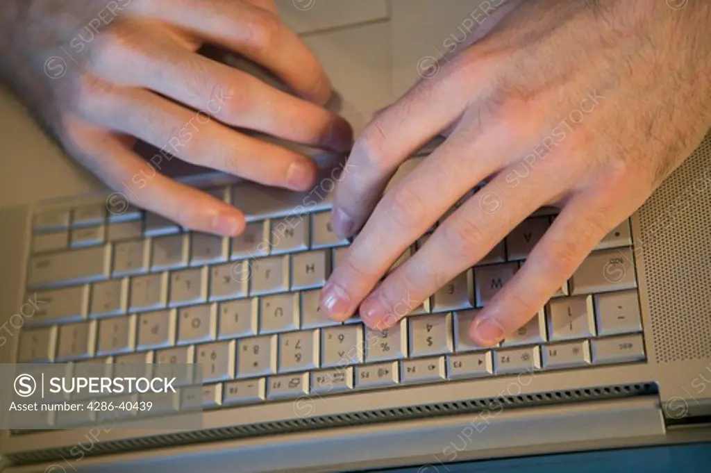 Mans hands and laptop computer.  MR-0511 PR-0505