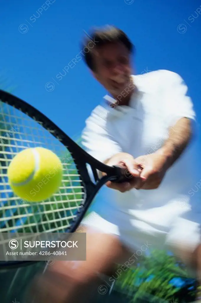 Tennis player returning ball.  