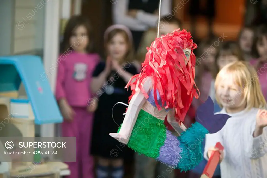 Children Trying to Break Open a Pinata at a Birthday Party