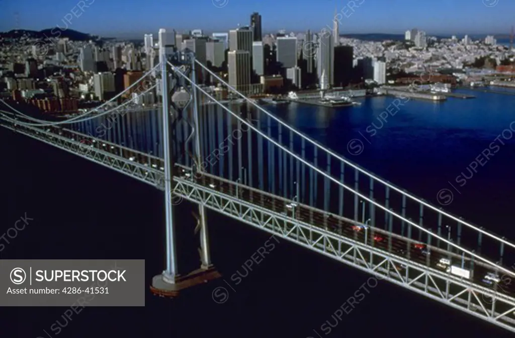 Aerial view of cars on San Francisco Bay Bridge with the San Francisco skyline in background.