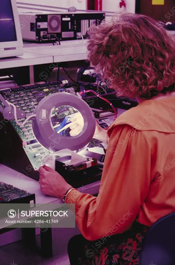 female using magnifying lens, computer drive testing, CA
