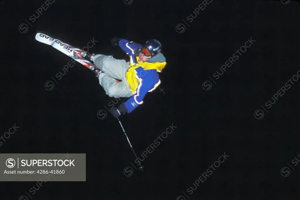 snow skier jumps at night 