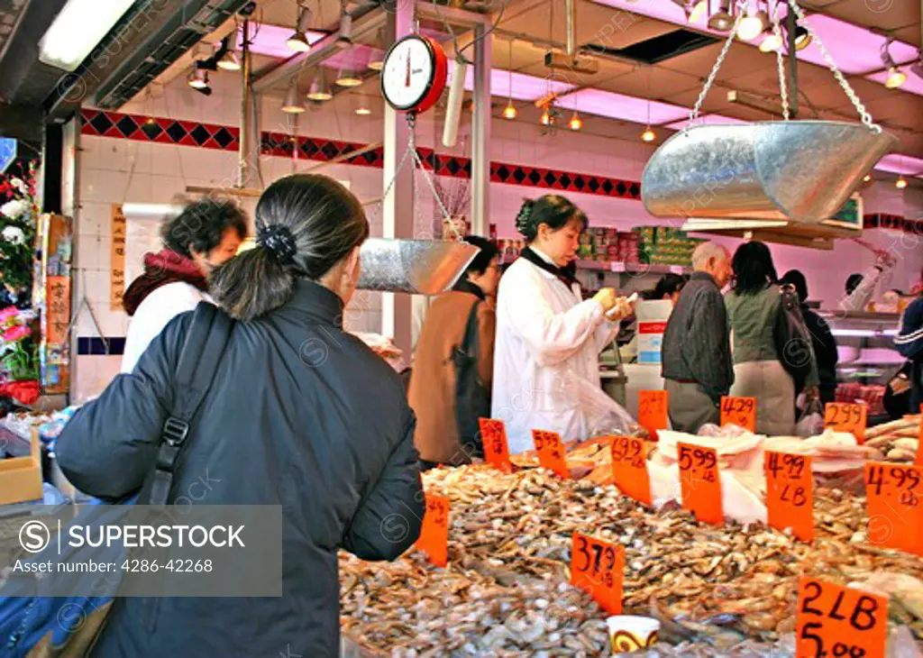 Ethnic people shopping seafood market on Canal Street Chinatown New York City