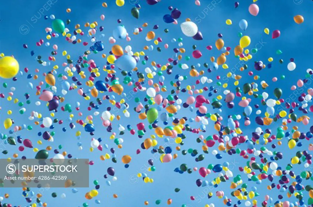various colored balloons drifting into sky