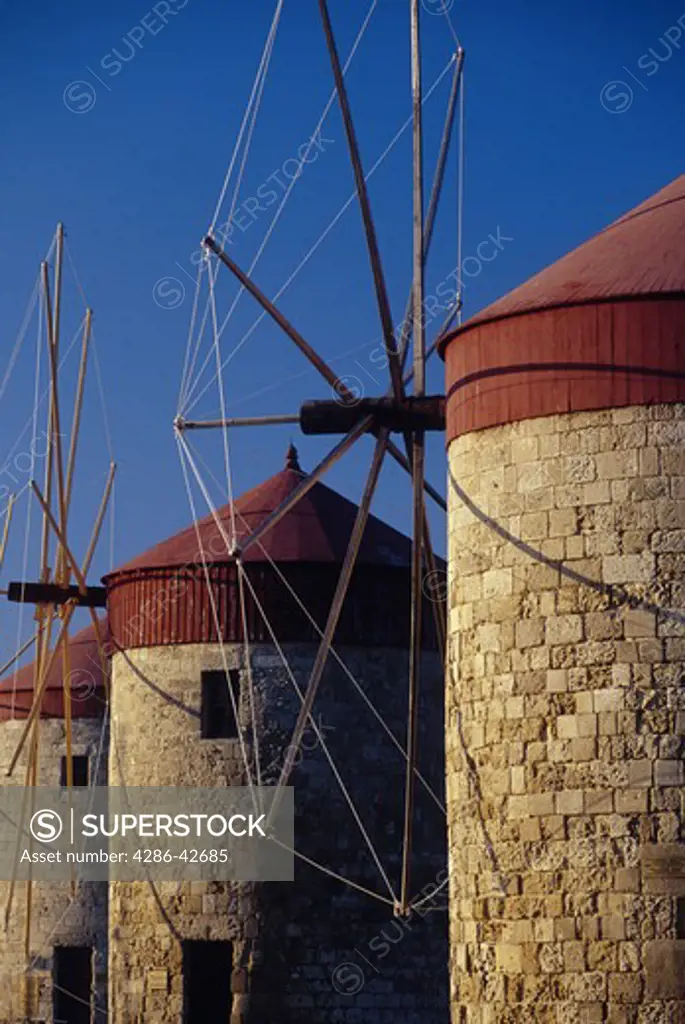 A trio of old windmills stand by the city of Rhodes. 