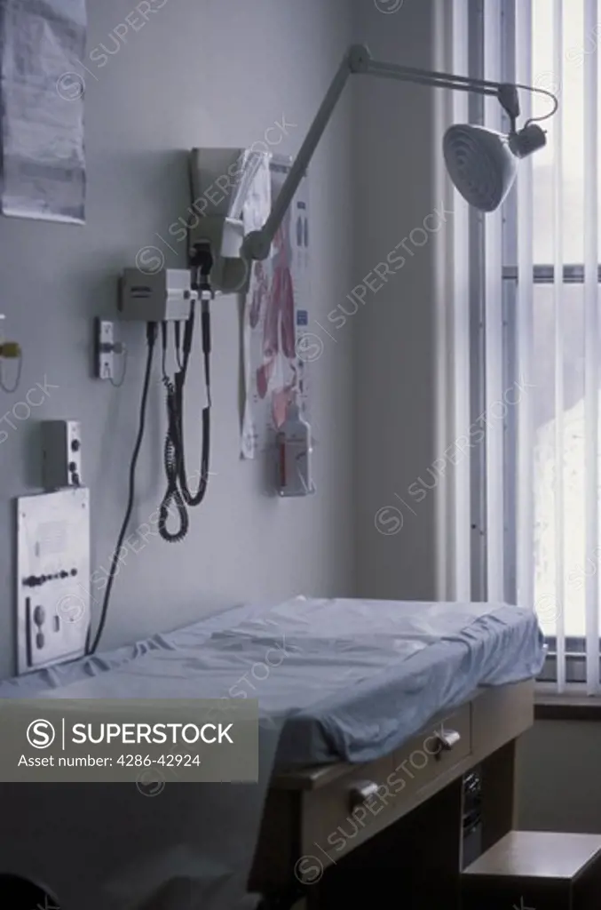A table and wall-mounted equipment in a hospital examining room.