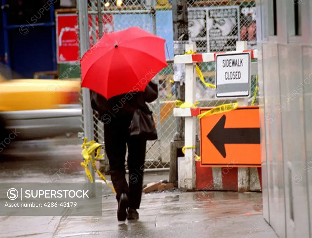 Pedestrian in the rain in lower Manhattan, NYC.