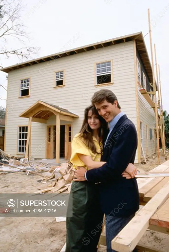 Couple in front of home under construction
