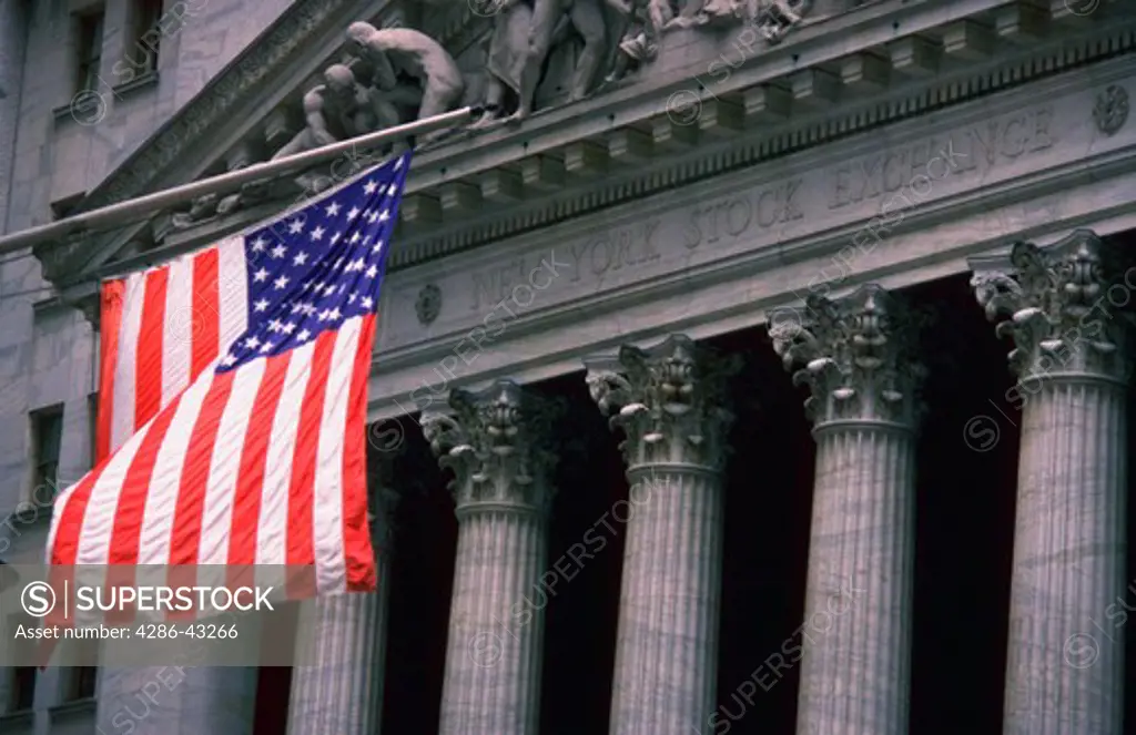 An American Flag waving in front of the New York Stock Exchange building in New York City, New York.