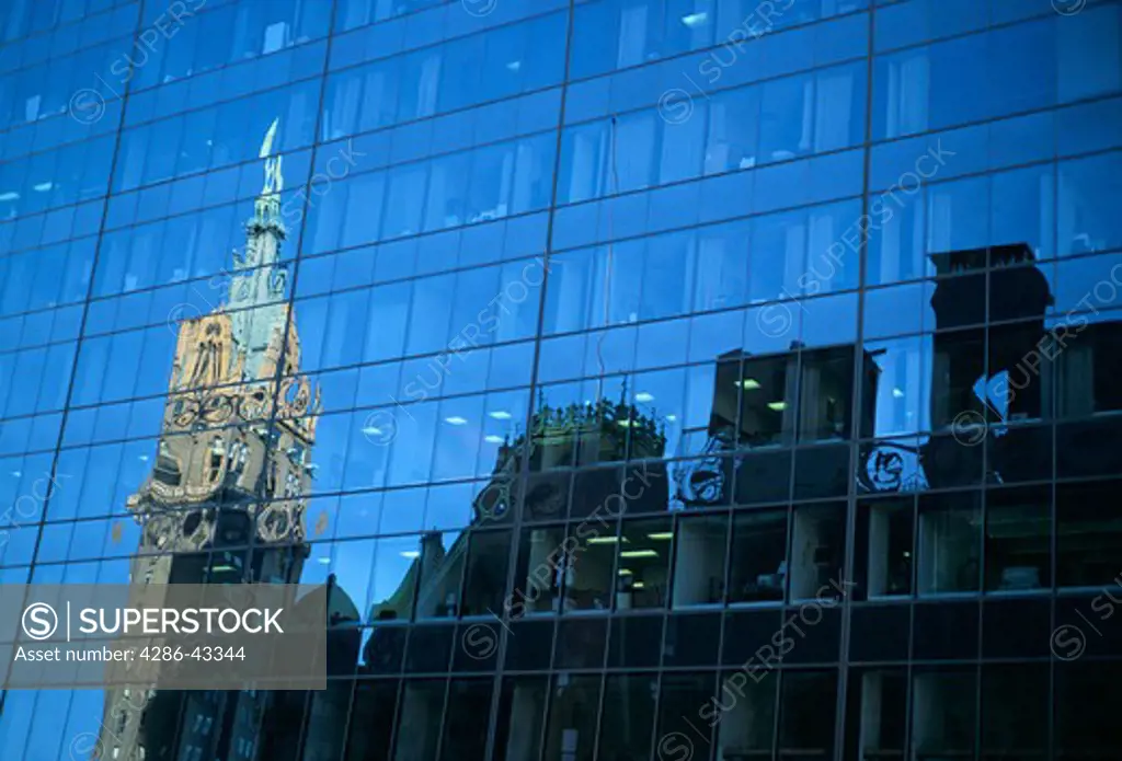 Reflections of skyline of buildings on glass office building, New York City.