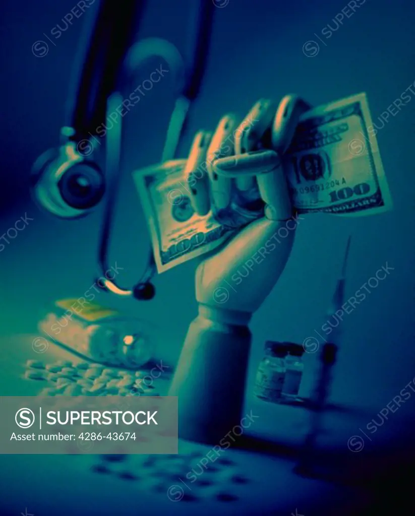 Medical still-life with hand holding money, stethescope, and pills