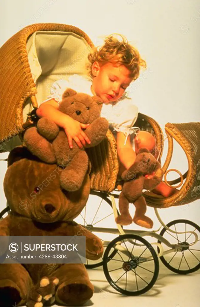 Young girl playing in antique stoller with teddy bears.