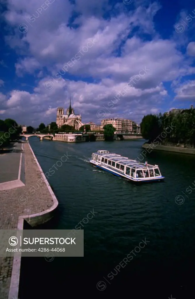 VIEW OF THE SEINE RIVER WITH SIGHTSEEING BOAT AND THE CATHEDRAL OF NOTRE DAME PARIS FRANCE