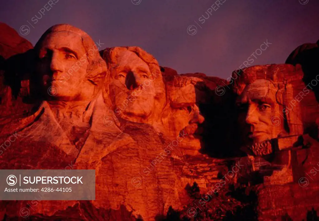 Mt. Rushmore glows red in the light of sunrise.