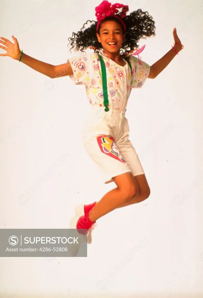 Young African American girl jumping in the studio.