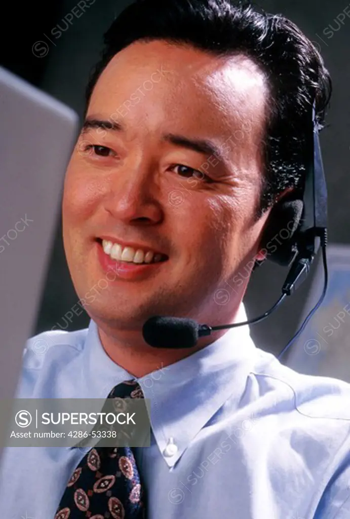 Asian businessman talking with telephone headset.