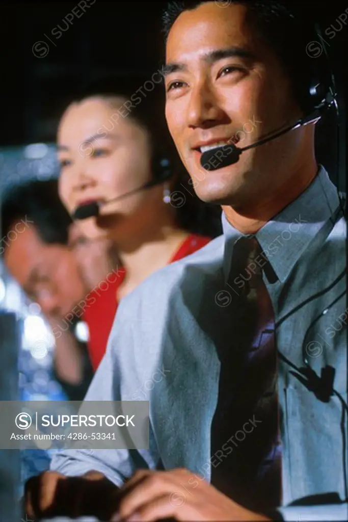 Telephone operators wearing headsets.