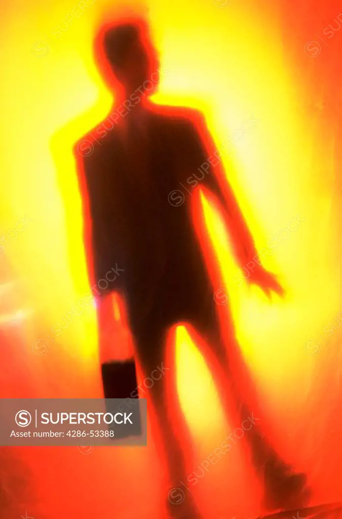Blurred image of a businessman carrying a briefcase with and orange background.