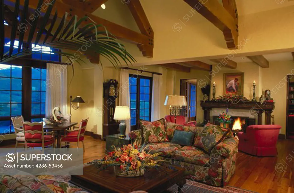 Interior view of a traditional Manor-style living room with hard wood floors and a fireplace.  Property released.