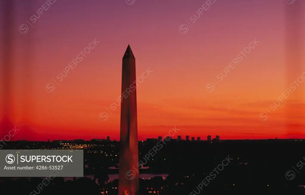 The Washington Monument rises above the Washington, DC skyline at sunset.
