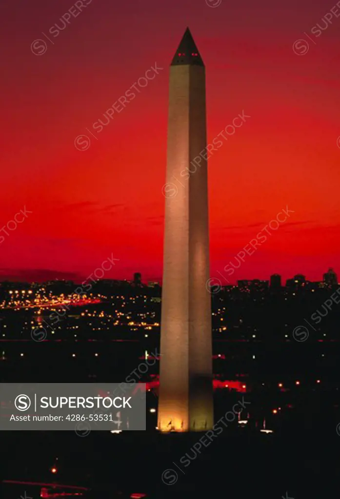 The Washington Monument rises above the Washington, DC skyline at sunset.