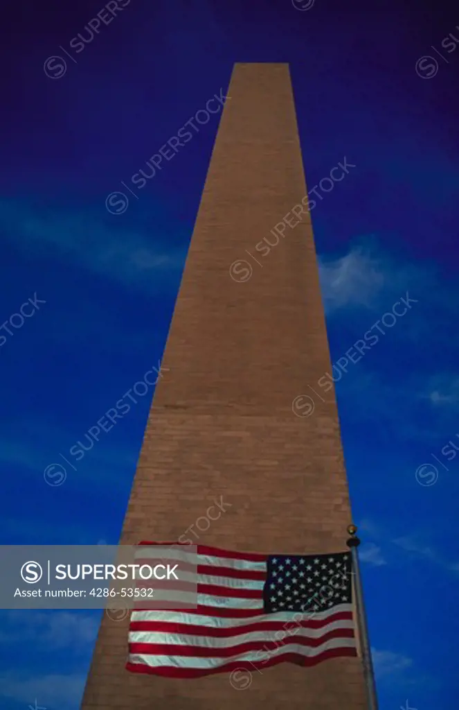 Looking up the Washington Monument with the American flag flying at the base of the monument, Washington, DC.