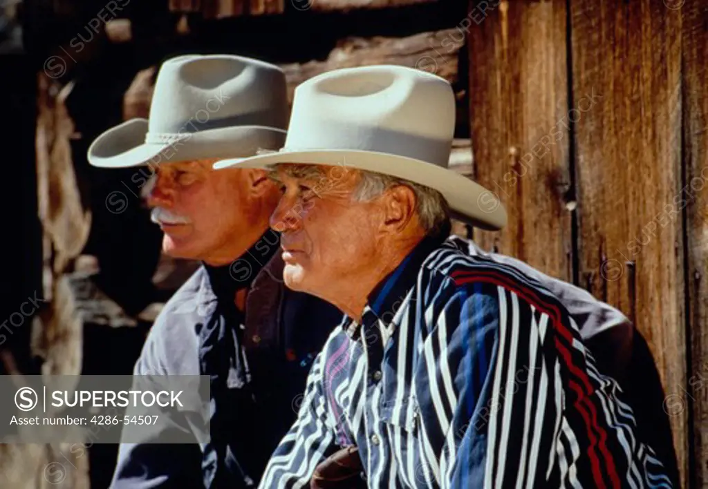 Portrait of two male wranglers in cowboy hats.