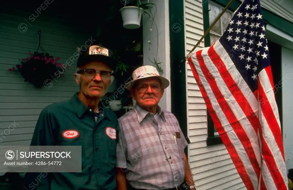 Service Station owner and farmer Hap Gaylord, left, and his lifelong friend Gayland Freeman pose on Hap's porch on flag day in Waitsfield, Vermont.