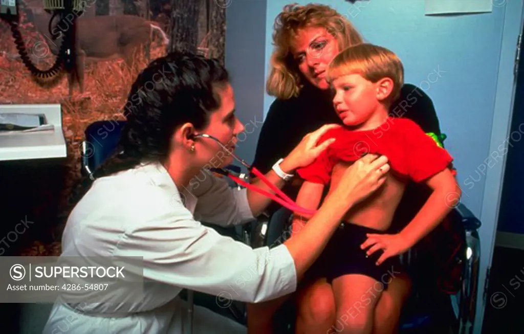 Registered nurse examines a young boy as his mother holds him at the Primus Clinic, Burke, Virginia. (model released)