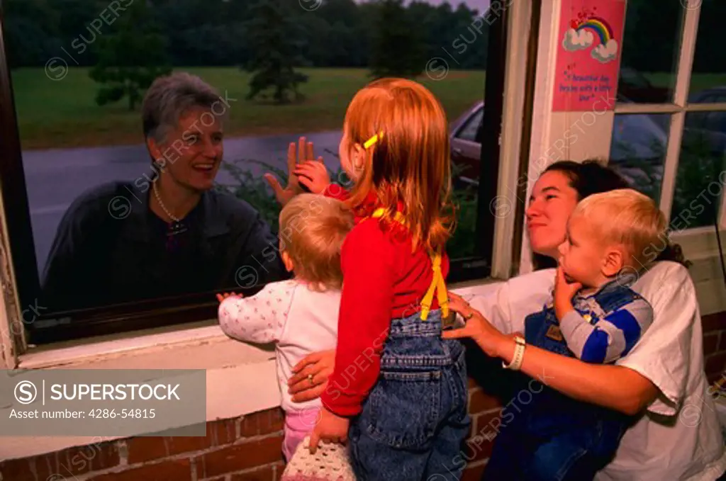 Children say good-bye to parents through a window at a private day care center in Providence, Rhode Island.