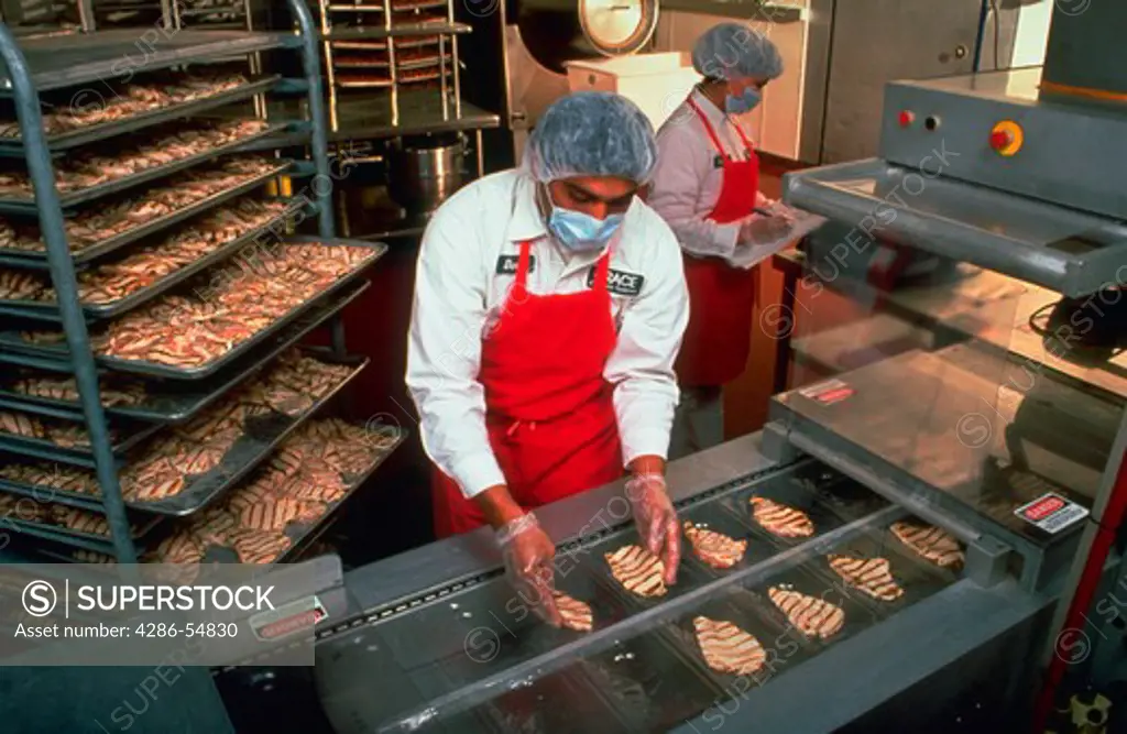 Vacuum-packed ('sous-vide') chicken at Grace Culinary Systems, Laurel, Maryland. Employee David Murcia places 'marked' (partially cooked) chicken breasts into plastic sheets for packaging. Restaurants and food services need only microwave the meat to complete cooking.