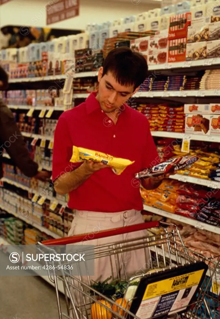 Man compares groceries at Safeway supermarket in Arlington, Virginia. (model released)