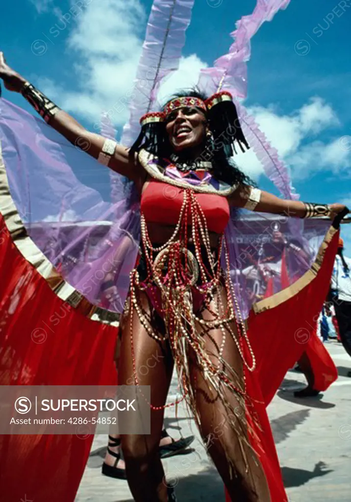 Dancer in elaborate costume performs on reviewing stage during annual Mardi Gras carnival in Port of Spain, Trinidad.