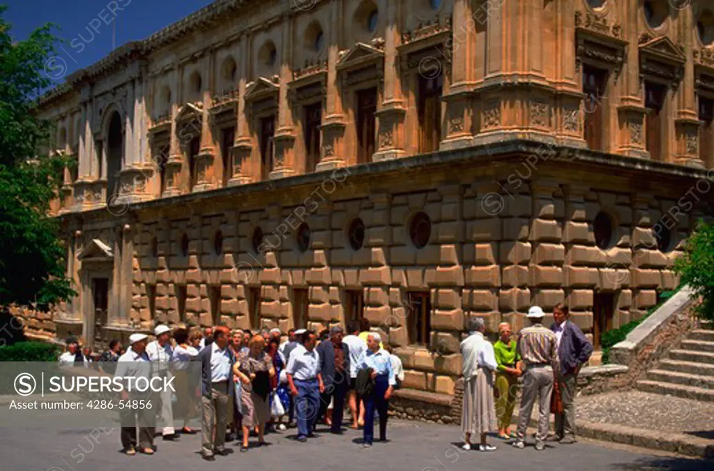 Tourists pass by the Carlos V Palace, one of the buildings at the famous Alhambra in Granada, southern Spain.