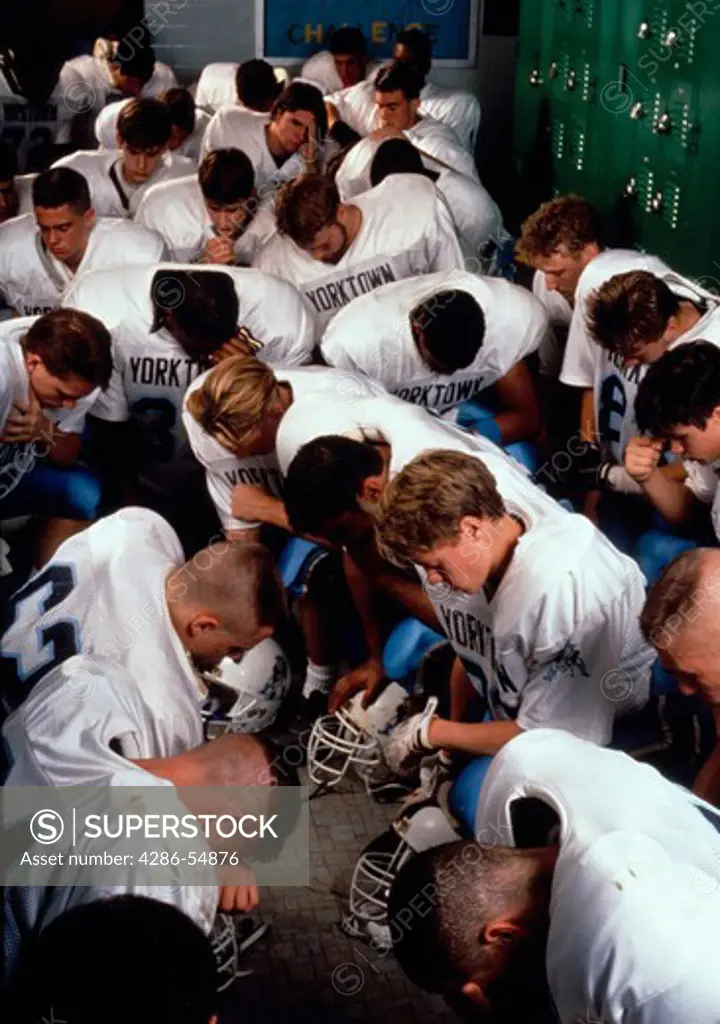 Yorktown Patriots high school football team kneels in locker room for a moment of silence before game in Arlington, Virginia.