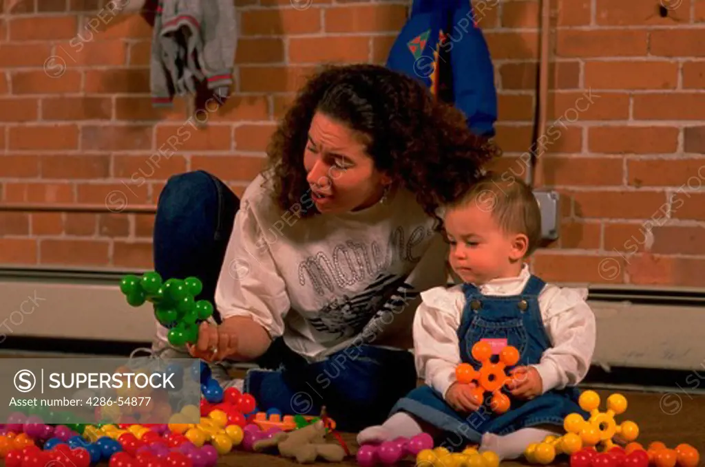 Female employee plays with infant at non-profit, private day care center for children 6 weeks to 5-years-old in Providence, Rhode Island.