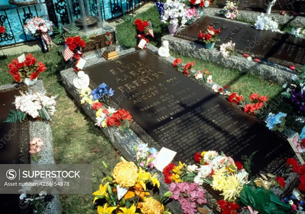 Flowers and small offerings bedeck the grave of musician Elvis Presley in the Meditation Garden at Graceland, Memphis, Tennessee.