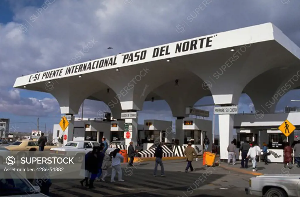 People and vehicles move toward the border and customs checkpoint on Avenida Juarez in Ciudad Juarez, Mexico. 'El Paso del Norte' (the north pass) is the entrance to the 'Puente Internacional' (the bridge crossing the Rio Grande River from Ciudad Juarez to El Paso, Texas, USA).