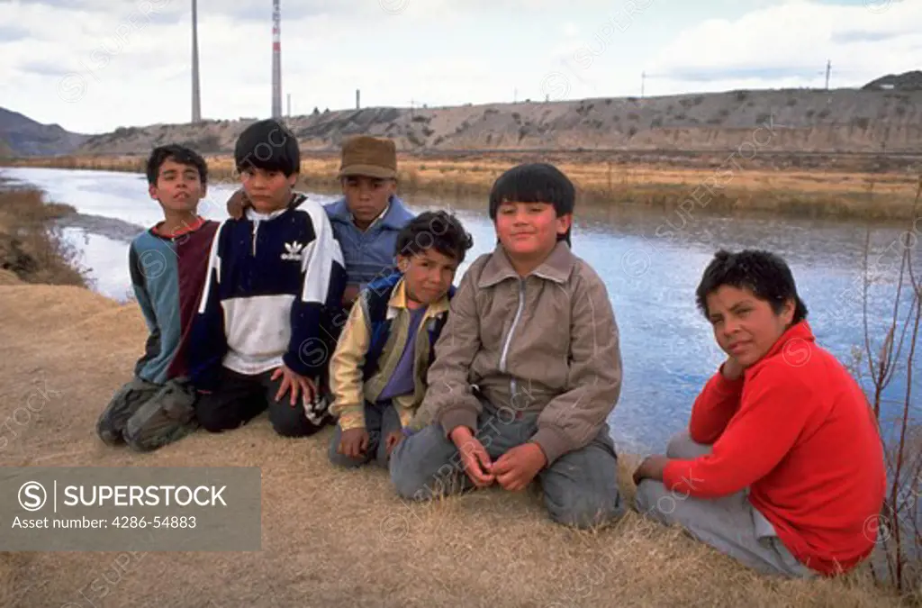 Six boys pose on the bank of the Rio Grande River in Ciudad Juarez, Mexico. Visible behind them across the river is El Paso, Texas, USA.