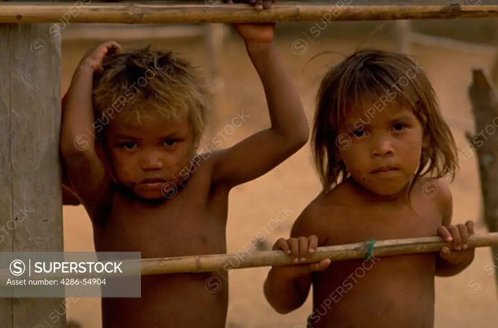 Two Yaruro indian children look through a fence at the Piedra Azul settlement indian reservation in Apure State, Venezuela.