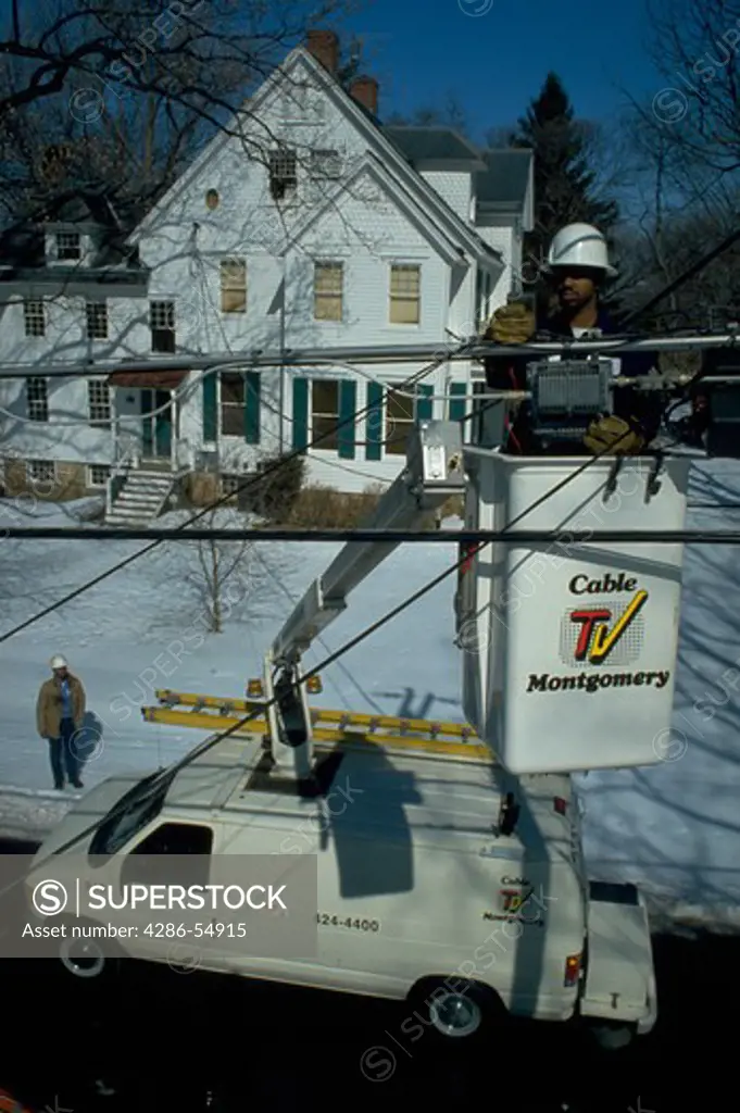 Line Technician Larry Price checks cable TV connections from bucket for Cable TV Montgomery in Rockville, Maryland.