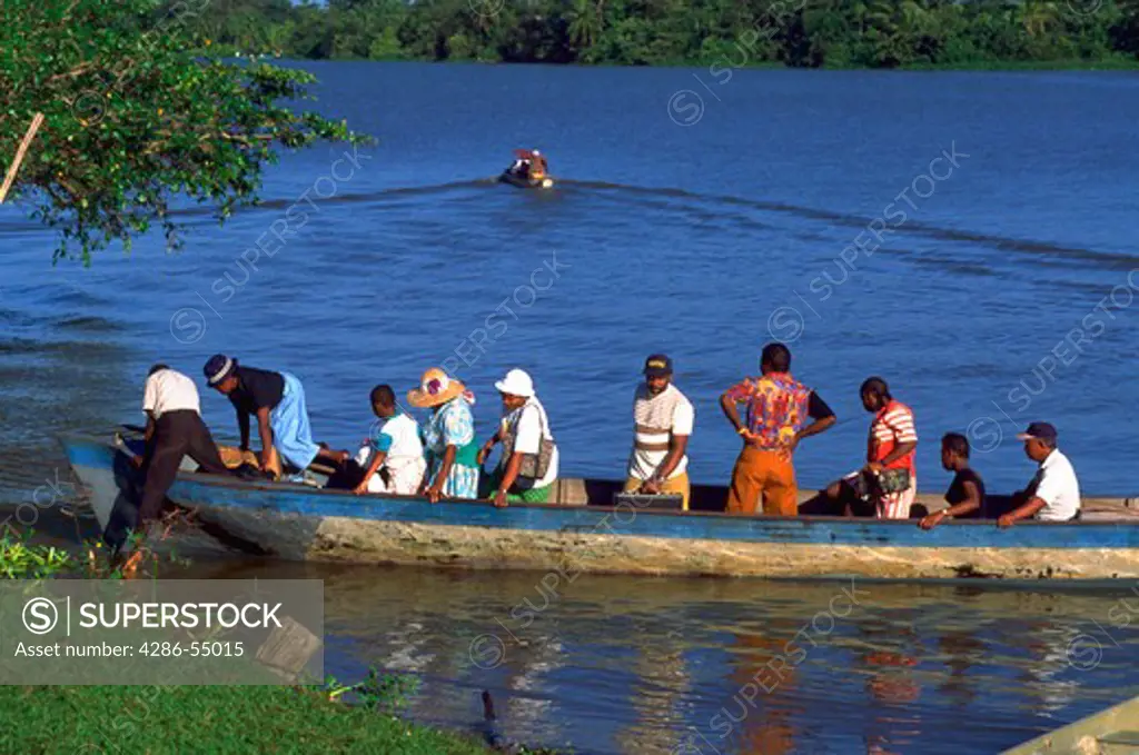 Groupo f Garifuna people in dugout boat arriving at Palacios, Honduras.